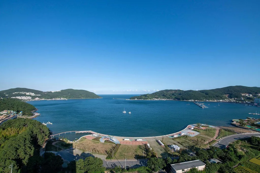 호텔 앞 지세포항 수변공원. 산책로가 항구를 따라 곡선으로 이어져서, 유람선이랑 요트가 오가는 걸 보기 좋아요. 저녁엔 노을이 이 항구 쪽으로 져서 산책하기 딱이에요.